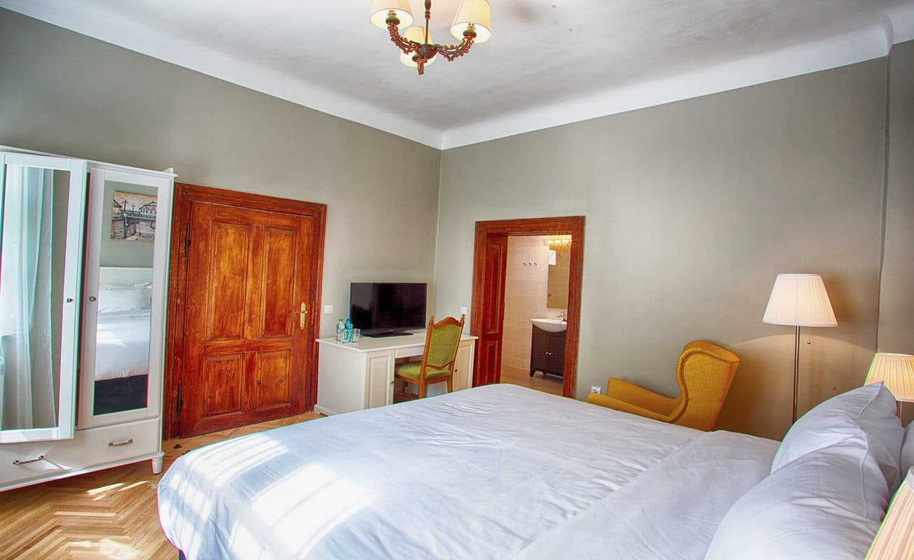 The standard double room, with a wardrobe, television and armchair.