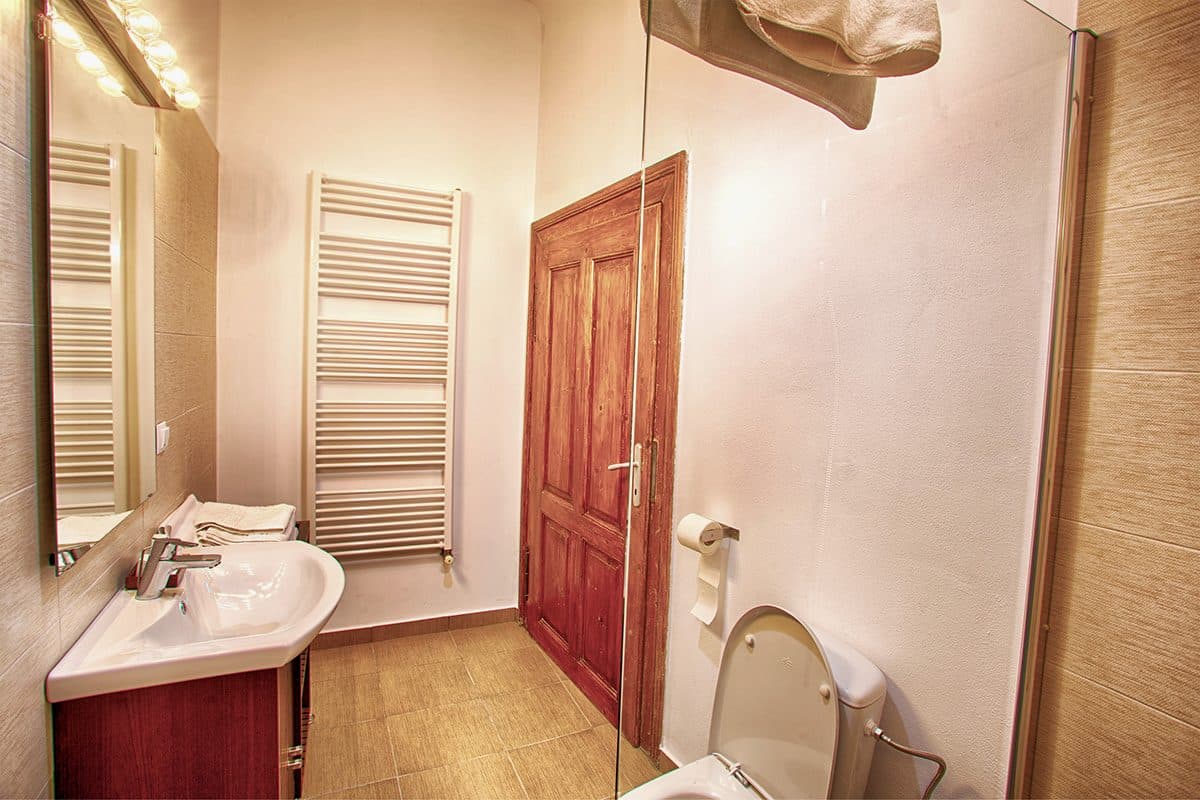 The standard room's bathroom, with a heated towel rail and wooden furniture.