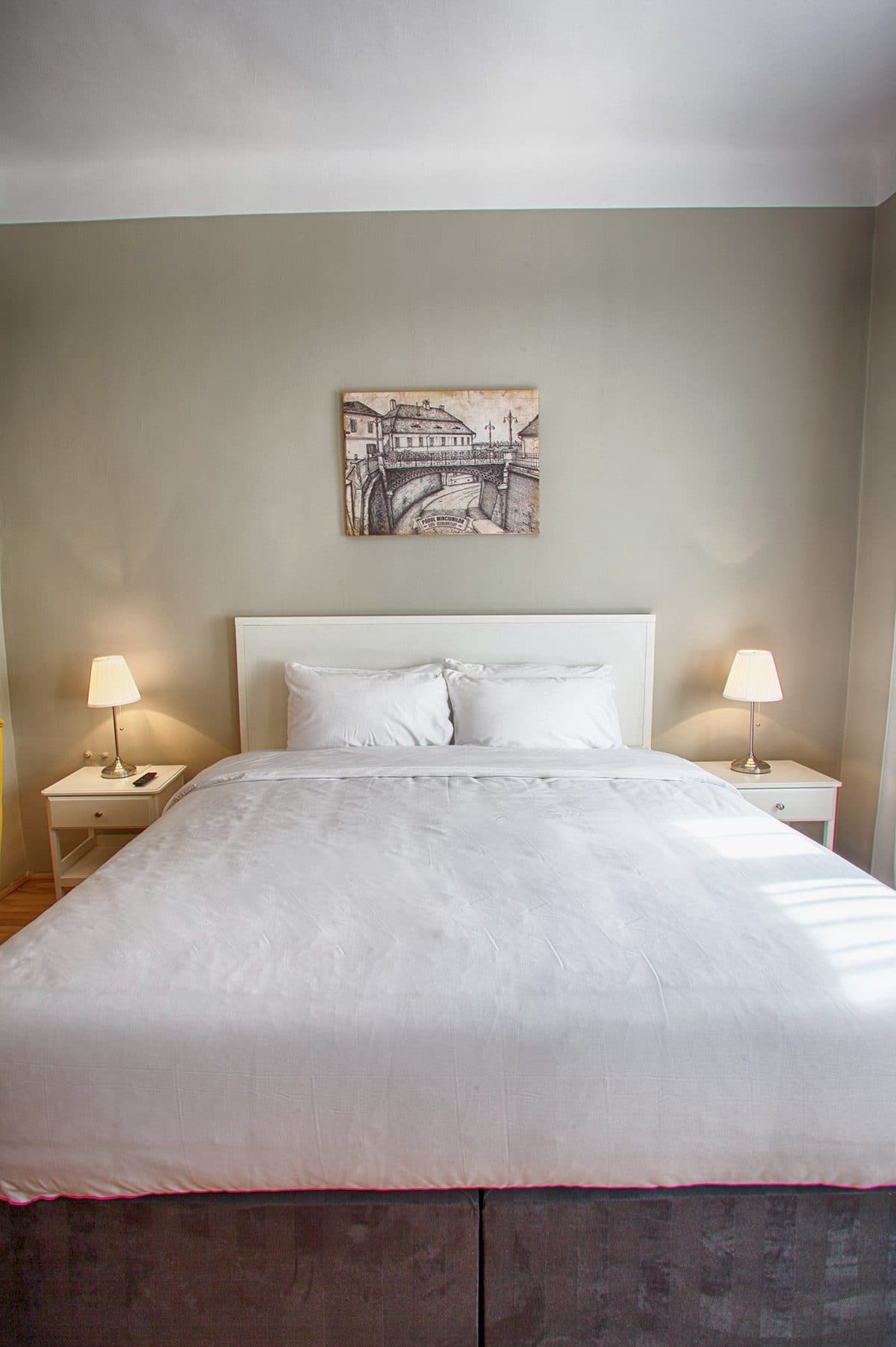 The double bed in the standard room, made, seen from the foot.