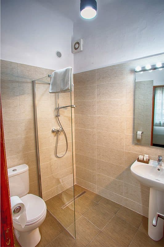 The shower cubicle in a superior room's bathroom, with the basin beside it.